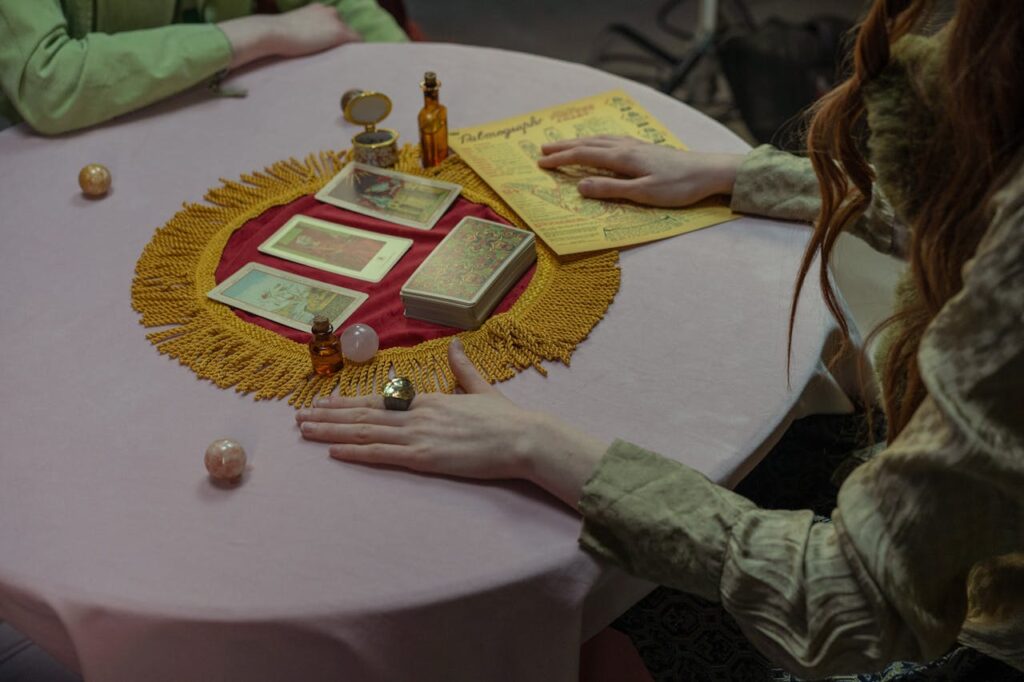 A Person Sitting at a Table with Tarot Cards